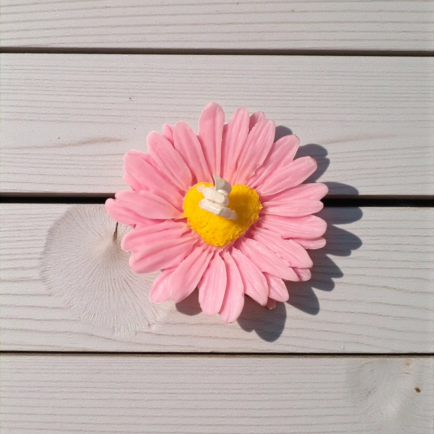 Candela decorativa margherita rosa con cuore giallo, ideale come regalo romantico o bomboniera.