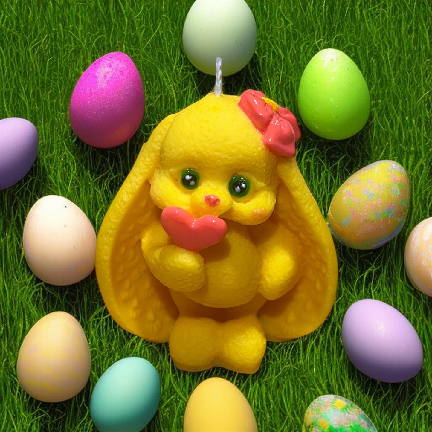 Candela decorativa coniglietta gialla con cuore e uova pasquali colorate.