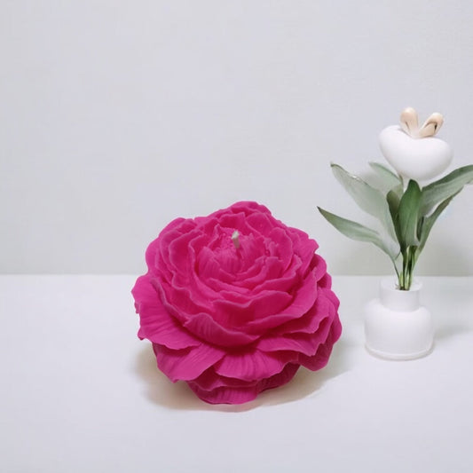 Candela artigianale profumata a forma di peonia fucsia, creazione floreale firmata Essenza di Luce.
