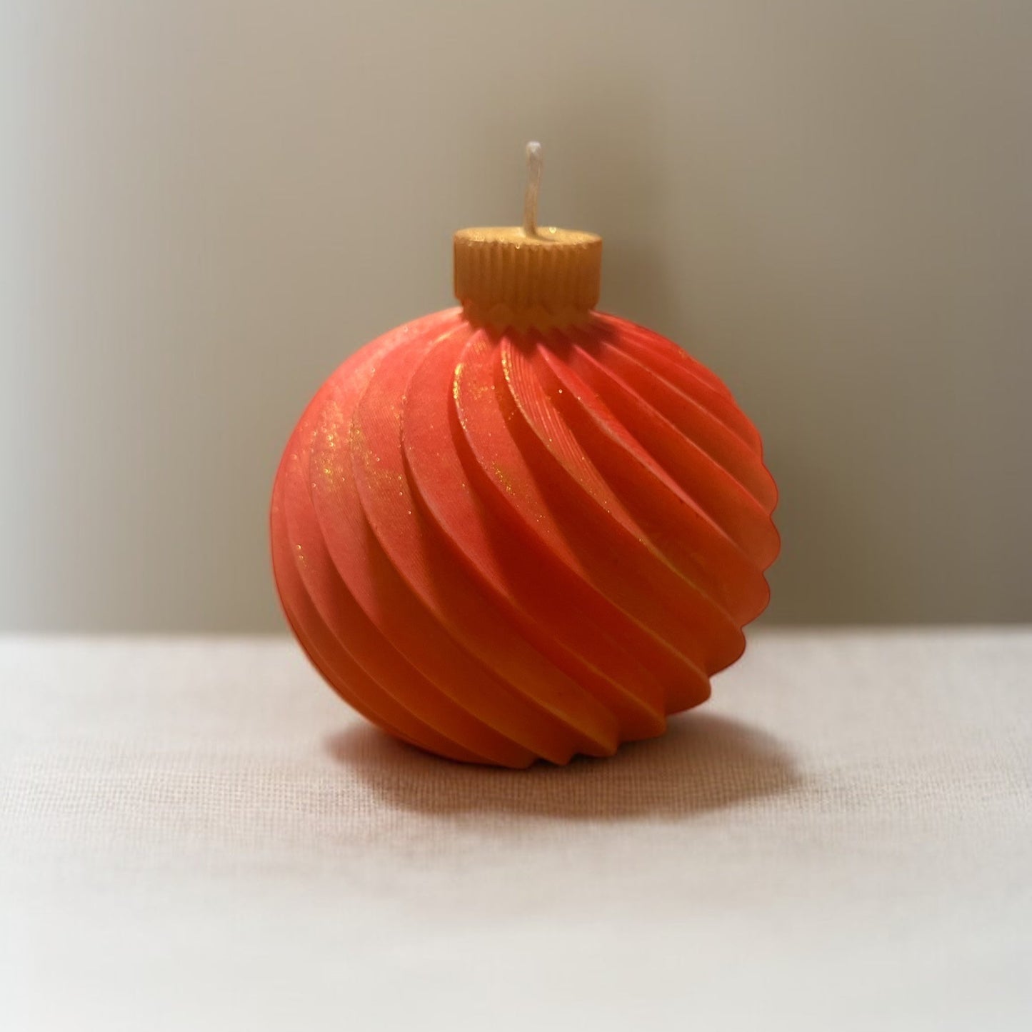 Candele a forma di sfera natalizia artigianale, profumate e disponibili in diversi colori, ideali per decorazioni o regali di Natale.