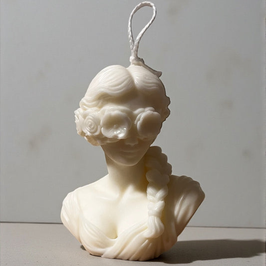 Candela decorativa Dea Bendata in cera bianca, scultura femminile con dettagli floreali, realizzata artigianalmente.