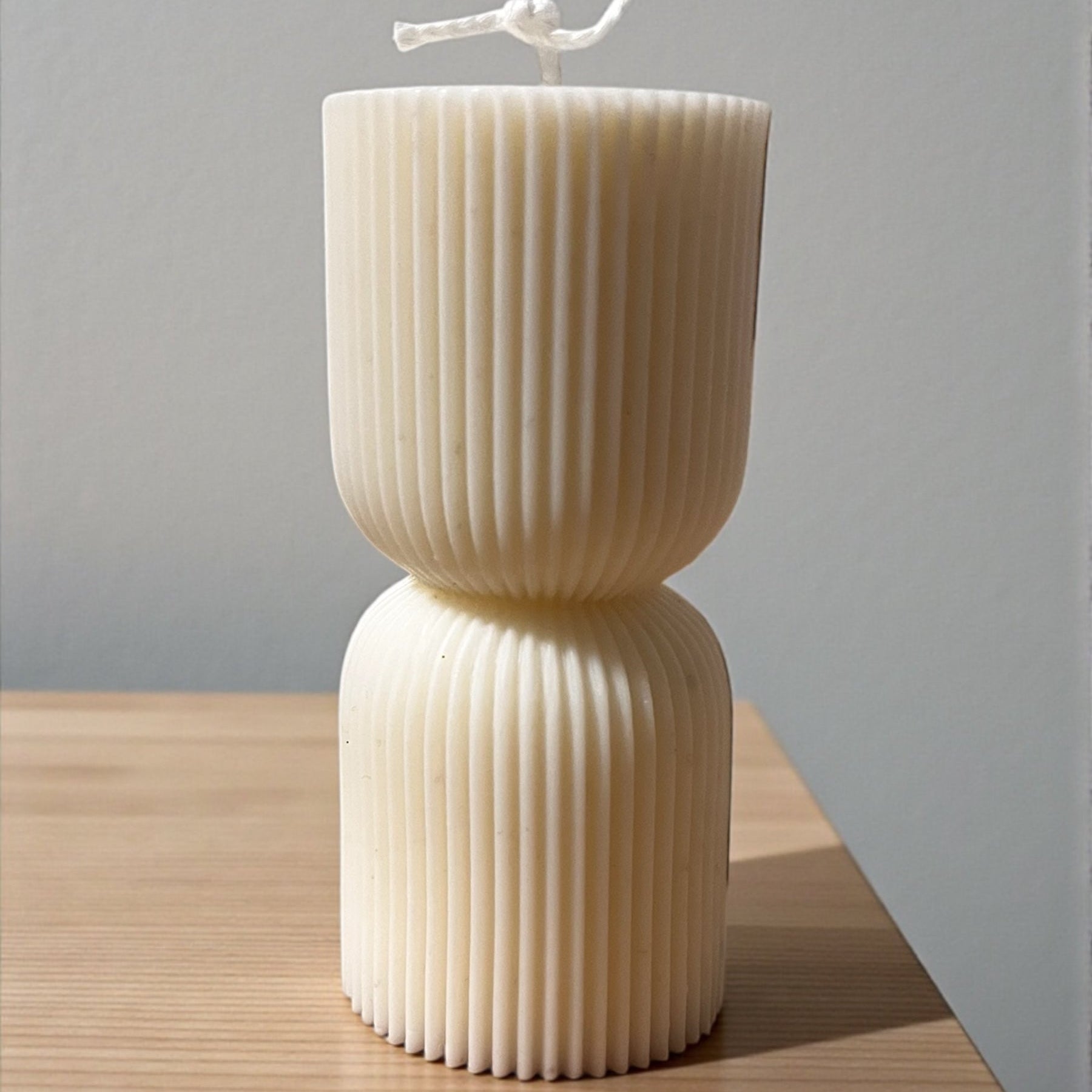 Candela decorativa Colonna d'Ercole in cera chiara dal design moderno e scanalato, realizzata artigianalmente