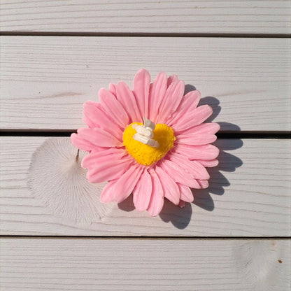 Candela decorativa margherita rosa con cuore giallo, ideale come regalo romantico o bomboniera. 