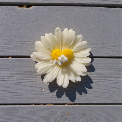 Candela decorativa a forma di margherita con cuore giallo, realizzata artigianalmente in cera.