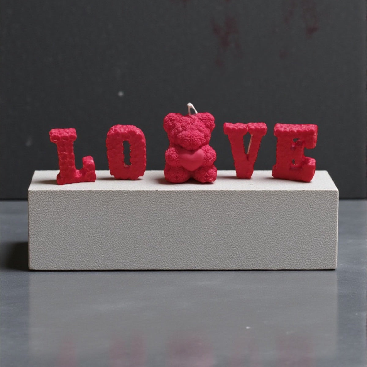 Candela decorativa Love & Orsetto in cera rossa, con scritta LOVE e orsetto centrale, ideale come regalo romantico.
