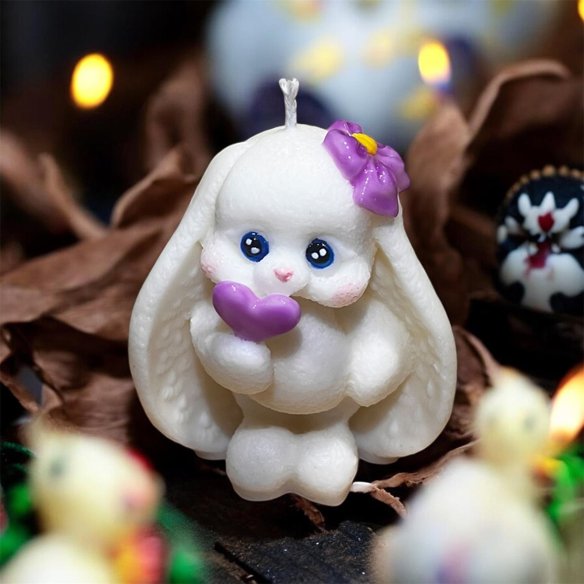 Candela artigianale coniglietta con cuore viola, perfetta come decorazione pasquale.